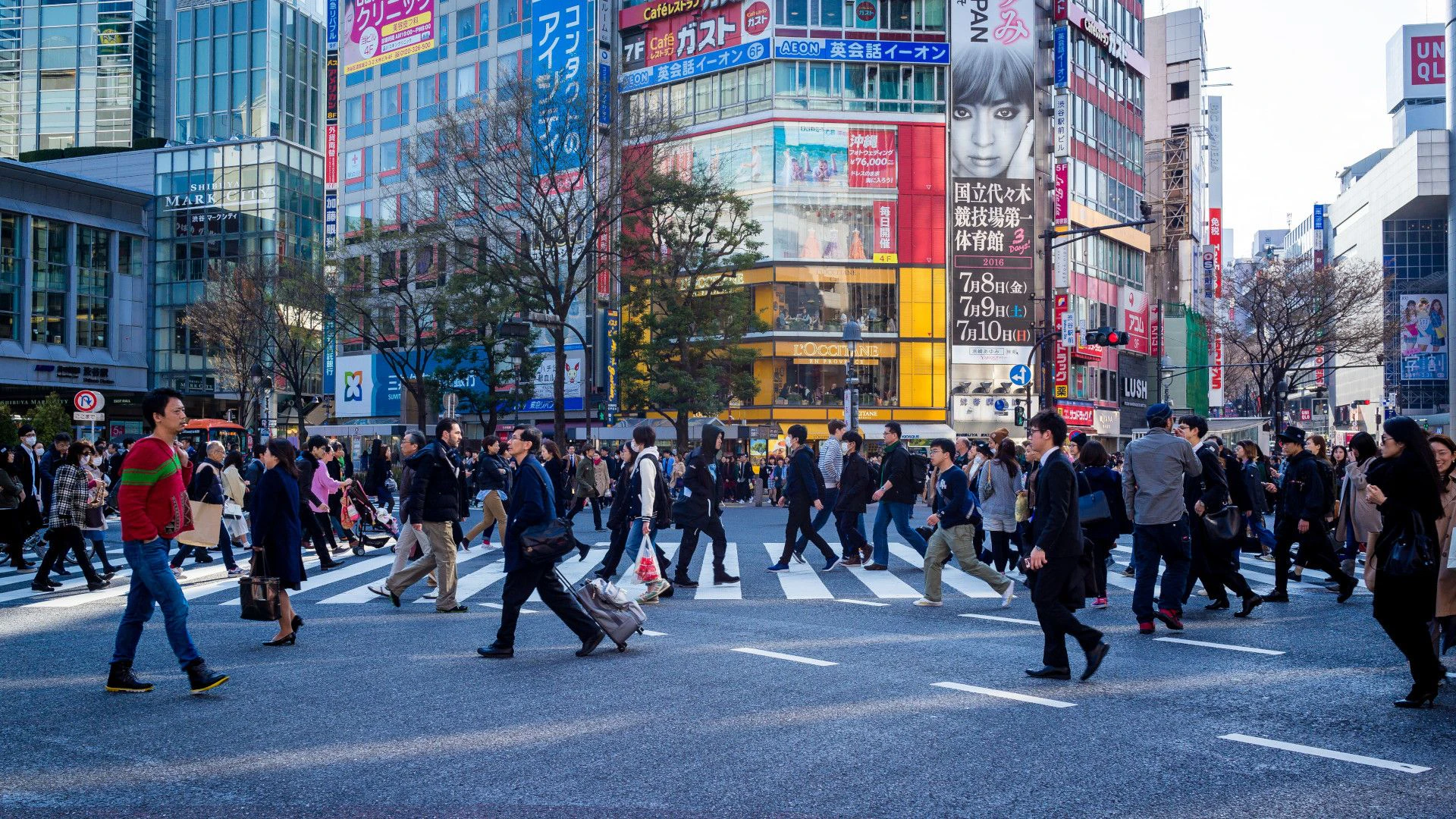 Menschen am Feierabend überqueren in Tokyo eine Kreuzung.